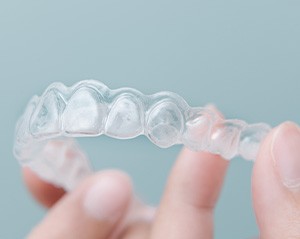 Patient holding up clear aligner