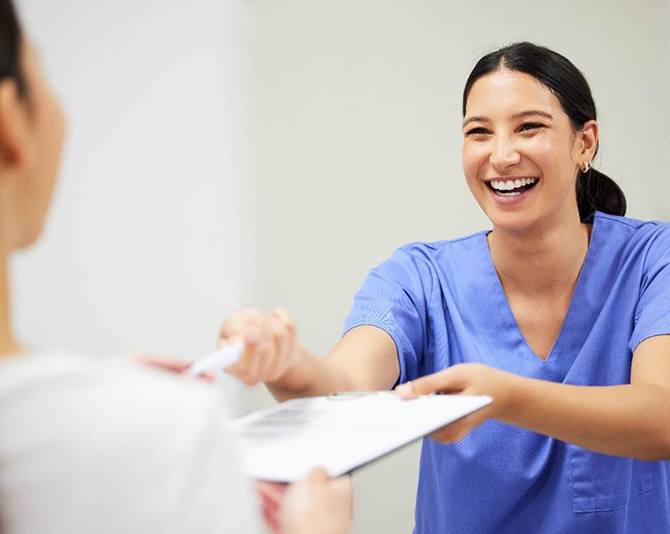 helpful staff member giving patient paperwork